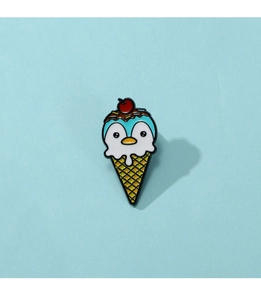 Detail of penguin ice cream enamel pin with cherry topping on light blue backdrop