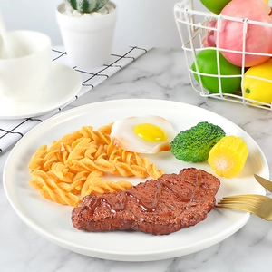 Realistische kunstmatige steakset met pasta, ei, broccoli en maïs op marmeren tafel