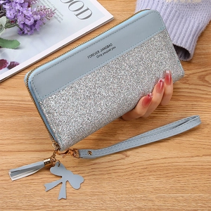 Detailed view of light blue zip-around wallet with silver glitter and tassel charm