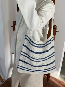 Detail of minimalist knitted tote bag in cream white with blue stripes texture