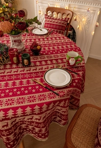 Close-up of festive red reindeer and snowflake jacquard patterns on round Christmas tablecloth
