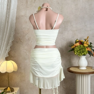 Rear view of cream white two-piece bikini set with ruched skirt on mannequin