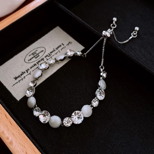 Detail of adjustable silver bracelet with white opal stones and faceted crystals