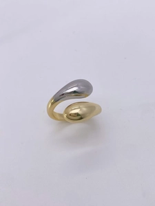 Detail of teardrop-shaped open ring featuring a dual-tone gold and silver polished finish