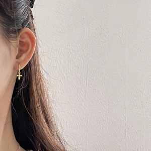 Side view of model wearing a minimalist gold cross dangle earring made of S925 sterling silver