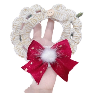 Handmade knitted Christmas pet collar with red bow and gold stars on white background