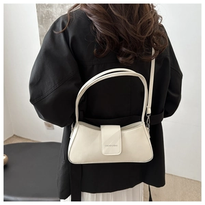 Detail shot of a white French baguette shoulder bag with stylish metal clasp closure