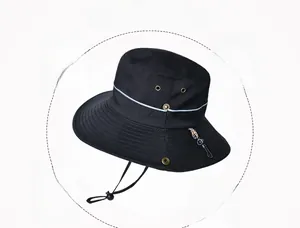 Détail d'un chapeau de soleil noir avec large bord, évents métalliques et jugulaire réglable