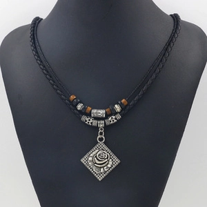 Detail of vintage leather cord necklace featuring silver rose pendant and beaded accents