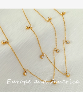 Macro shot of gold-plated necklace featuring tiny beads and sparkling zircon stones