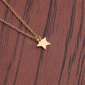 Polished gold stainless steel star pendant necklace on a natural wooden background