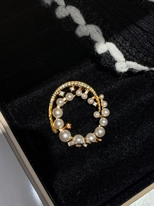 Detail of 24k gold plated round brooch with gradient pearls and sparking zircon stones