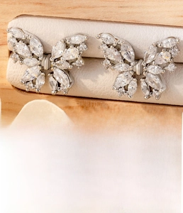 Macro shot of silver butterfly stud earring with sparkling cubic zirconia on a velvet stand