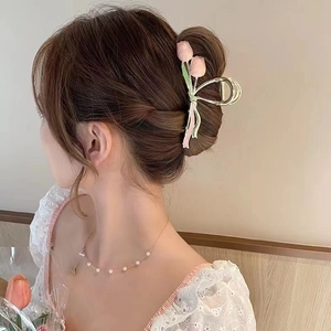 Detailed back view of a pink tulip shark hair clip styled on an elegant hair bun