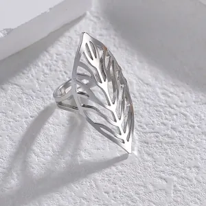 Minimalist stainless steel open ring with cutout leaf design on white stone background