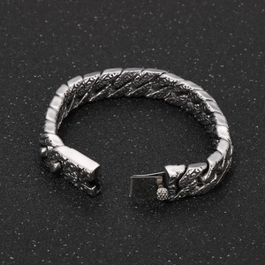 Macro shot of retro floral engravings on a silver stainless steel Cuban link bracelet