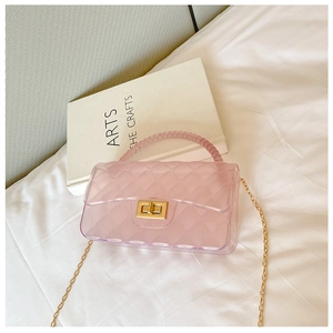 Pink transparent jelly bag with diamond lattice design and gold chain on white fabric