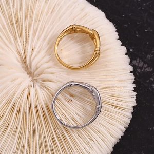 Close-up of gold and silver bamboo joint rings on white coral with soft lighting