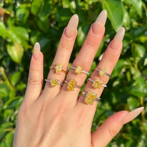 Macro view of assorted yellow gemstone rings with varied cuts on silver bands