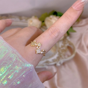 Detail of adjustable gold star ring with micro-set zircons and elegant white pearls