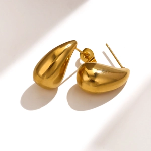Detailed close-up showing the high-polished 18K gold teardrop earrings with a smooth finish