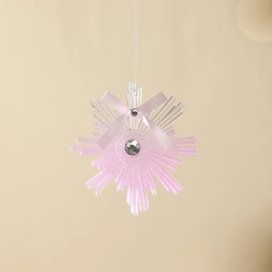 Pink glitter snowflake Christmas ornament with ribbon bow and faux diamond center