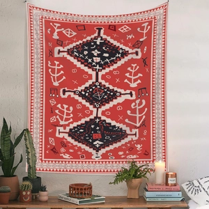 Detail of red Bohemian tapestry with tribal geometric patterns hung on a white textured wall