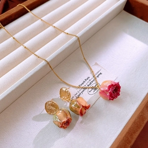 Detail of rose bud jewelry set featuring real flower resin pendants and gold chain