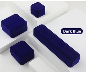 Detailed view of dark blue velvet jewelry boxes in various sizes on geometric blocks