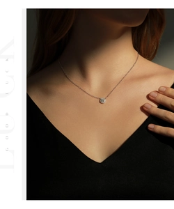 Dettaglio della collana con ciondolo in moissanite tonda brillante indossata da una modella