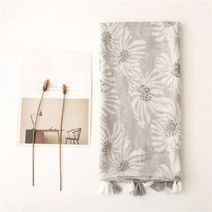 Détail d'une écharpe en coton et lin gris avec imprimé marguerites et franges