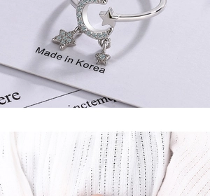 Detail of moon and star silver ring with micro-pave crystals on soft ribbed fabric
