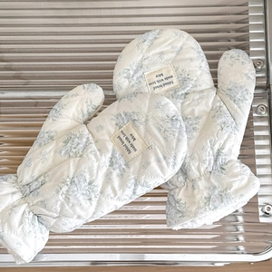 Close-up of floral quilted mittens with elastic cuffs and decorative brand label