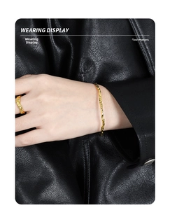 Wearing display of golden hammered texture bracelet and ring with black leather background