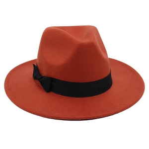 Close-up of rust red wool fedora with black grosgrain ribbon and bow detail