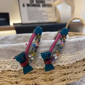 Detailed close-up of handmade bow hair clip with colorful crystals and metal base