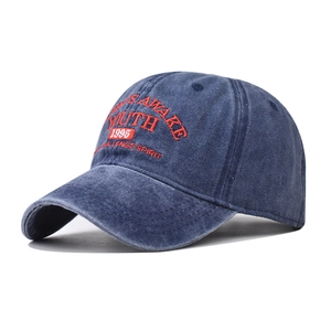 Detail of washed blue denim baseball cap with red YOUTH embroidery and quality stitching
