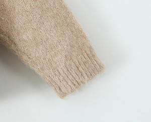 Close-up of soft ribbed cuffs on a beige mohair knit sweater showing fine fiber texture