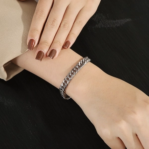 Close-up of a silver titanium steel Cuban link bracelet worn on a wrist for men