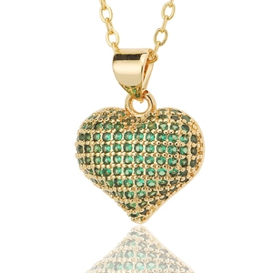 Close-up of luxury heart pendant necklace featuring micro-pave green crystals on gold base