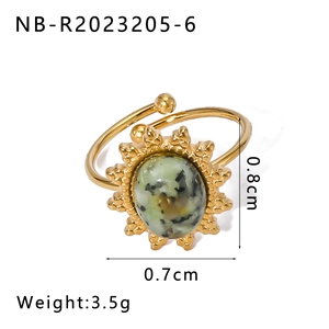 Macro detail of vintage gold plated ring featuring green stone and sunburst engraving