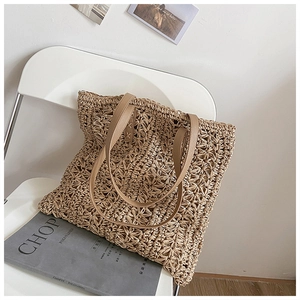 Detailed view of the woven hollow pattern and brown leather handle on a khaki tote bag
