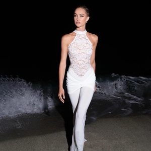 Elegant white lace patchwork jumpsuit for women featuring a halter neck and slim fit flared legs