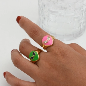 Detailed shot of 18K gold plated alien rings with pink and green enamel on model's fingers