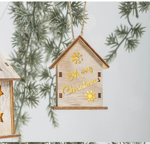 Dettaglio macro della casa di Natale in legno luminosa appesa a un ramo di pino