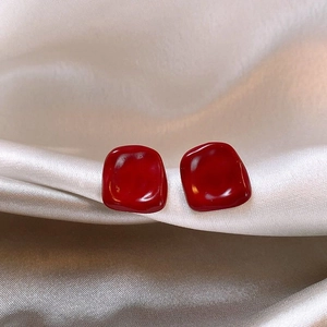 Deep red resin ball stud earrings with retro square texture on champagne silk fabric