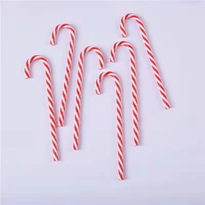 Close-up of five red and white spiral acrylic candy cane ornaments for Christmas tree