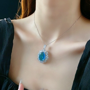Detailed close-up of an oval blue gemstone flower necklace on a model's neck