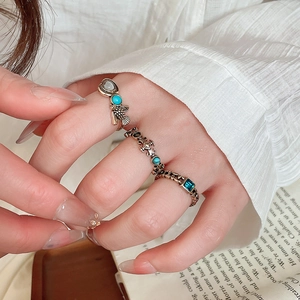 Detail of vintage bohemian ring set with turquoise and blue gems on model's hand