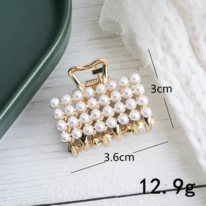 Detail view of small gold hair claw with white pearls including dimensions 3.6x3cm